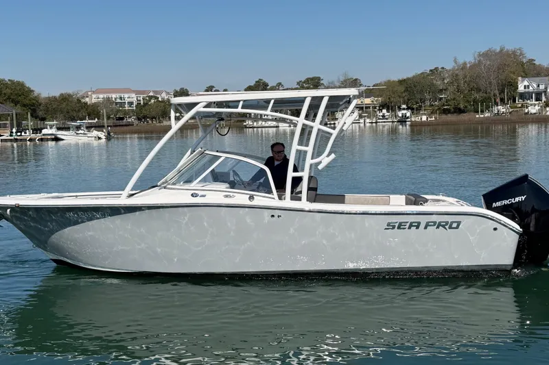 Slide: The Image of 2024 Sea Pro 240 Dual Console boat on calm water, featuring a Mercury engine. - 7
