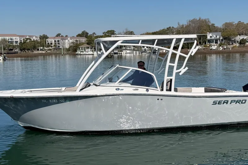 Slide: The Image of 2024 Sea Pro 240 Dual Console boat on calm water, with scenic background. - 8