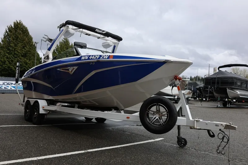 Slide: The Image of 2023 Tigé Z3 boat on trailer in parking lot, overcast sky. - 11