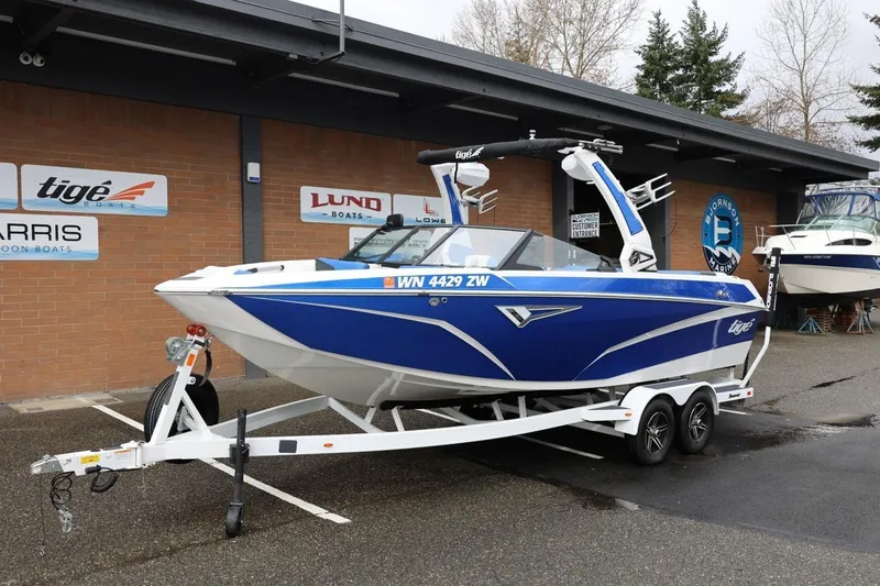 Slide: The Image of 2023 Tigé Z3 boat in blue on a trailer, parked outside a dealership. - 14