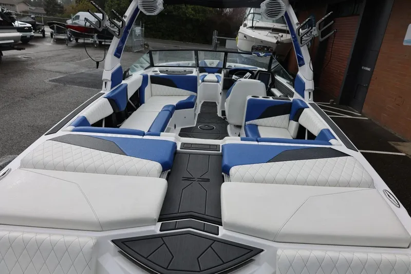 Slide: The Image of 2023 Tigé Z3 boat interior with blue and white seating, docked outdoors. - 20