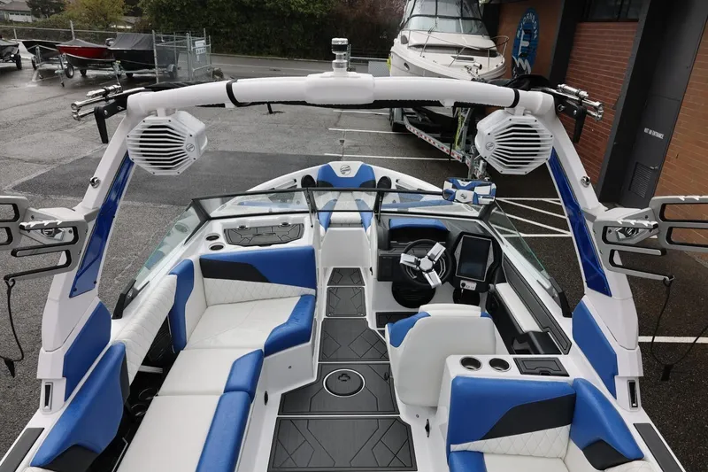 Slide: The Image of 2023 Tigé Z3 boat interior with blue and white seating, advanced dashboard, and speakers. - 26