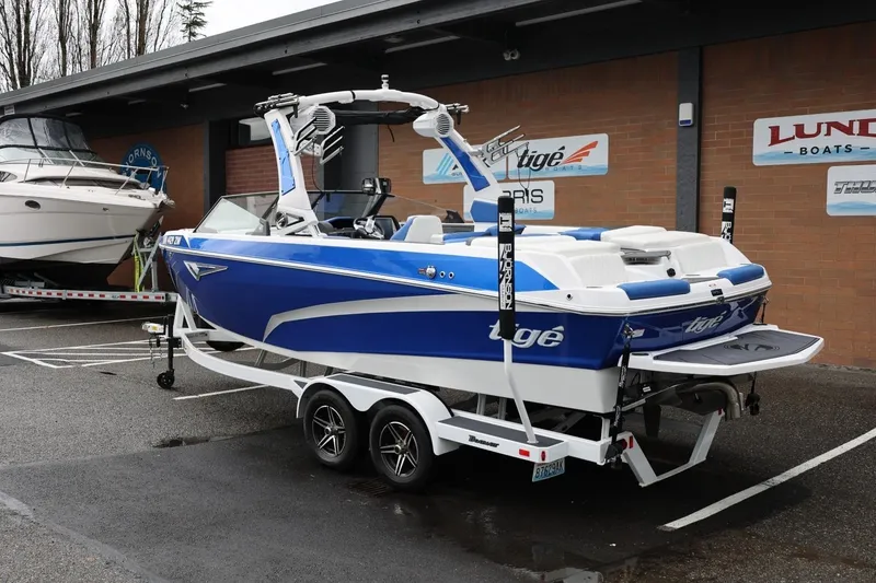 Slide: The Image of 2023 Tigé Z3 boat in blue and white on a trailer, parked outside a dealership. - 3