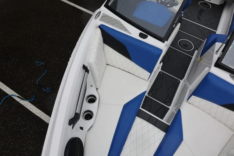 Slide: The Image of 2023 Tigé Z3 boat interior with blue and white seating, black flooring, and cup holders. - 42