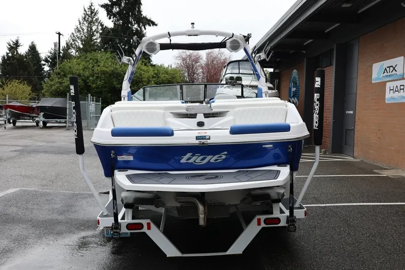 Slide: The Image of 2023 Tigé Z3 boat, blue and white, parked outdoors near a building. - 5