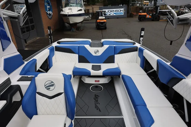 Slide: The Image of 2023 Tigé Z3 boat interior with blue and white seating, docked at a marina. - 53