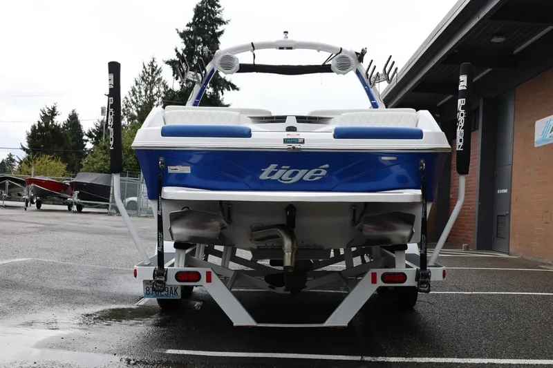 Slide: The Image of 2023 Tigé Z3 boat, blue and white, parked on a trailer in a lot. - 6