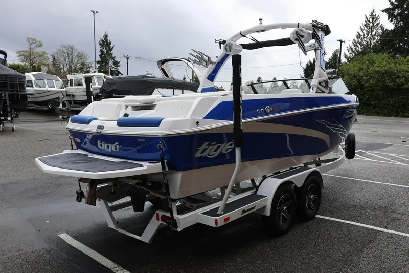 Slide: The Image of 2023 Tigé Z3 boat in blue and white on a trailer in a parking lot. - 8