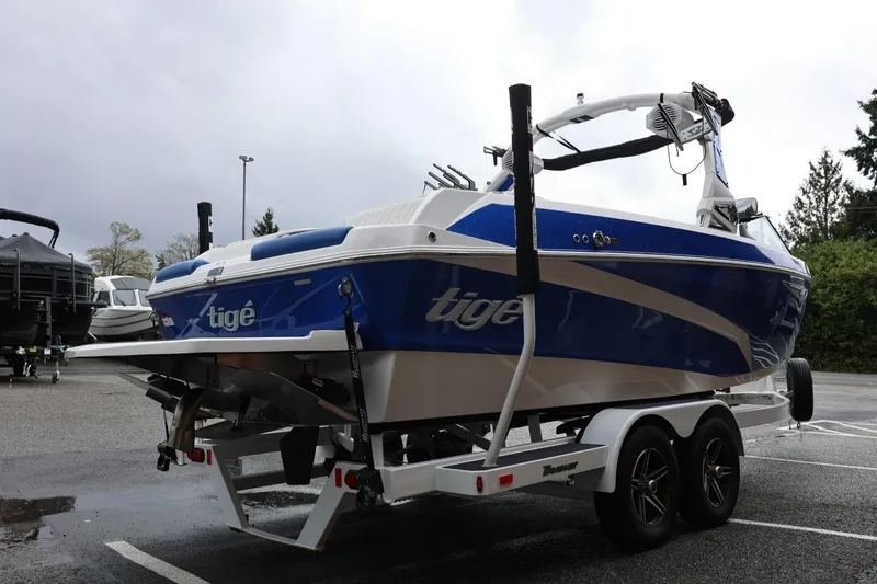 Slide: The Image of 2023 Tigé Z3 boat on trailer, blue and white design, parked outdoors. - 9