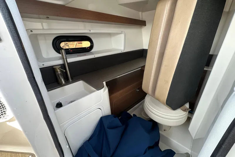 Slide: The Image of 2017 Sea Ray SDX 290 Outboard cabin interior with sink, toilet, and storage. - 17