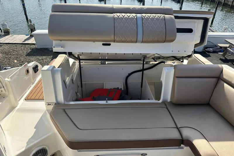 Slide: The Image of 2017 Sea Ray SDX 290 Outboard boat with open storage compartment and cushioned seating. - 22