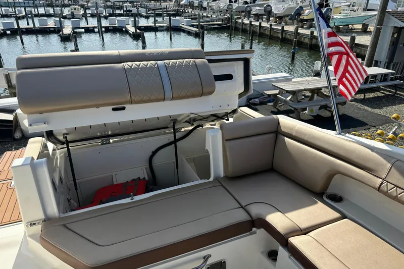 Slide: The Image of 2017 Sea Ray SDX 290 Outboard boat interior with seating and storage, docked at marina. - 23