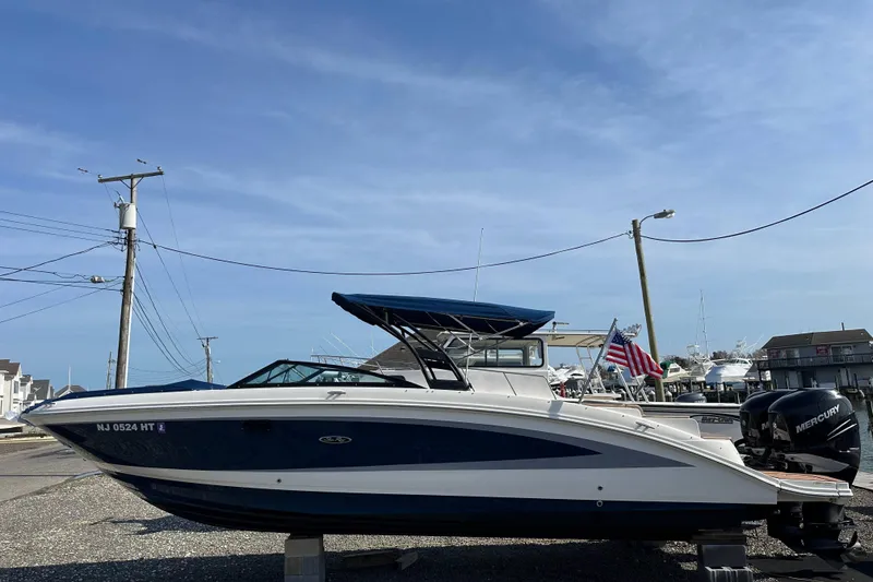 Slide: The Image of 2017 Sea Ray SDX 290 Outboard boat with blue canopy, docked in a marina. - 30