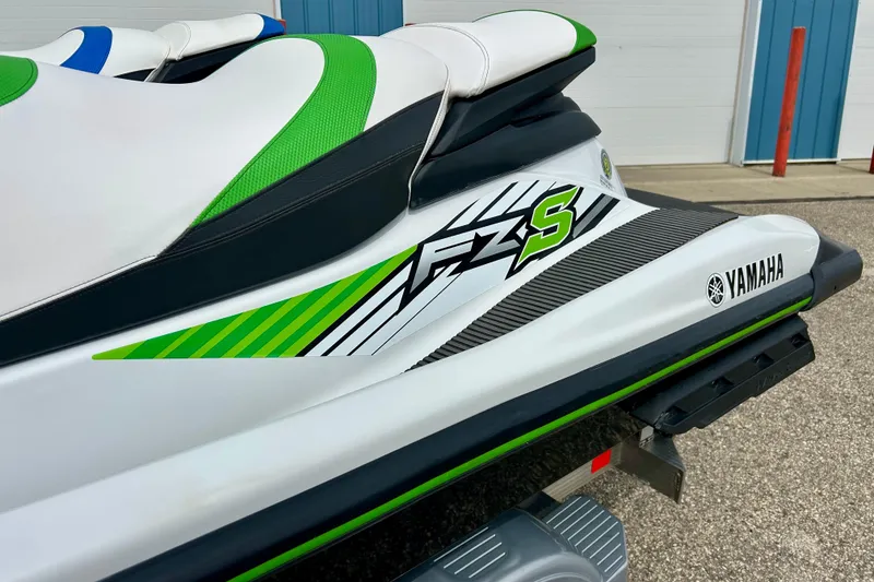 Slide: The Image of 2016 Yamaha WaveRunner FZS with green and white design, parked outdoors. - 21