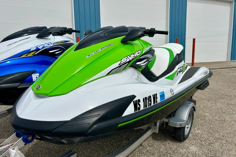 Slide: The Image of 2016 Yamaha WaveRunner FZS in green and white on a trailer, parked outdoors. - 23