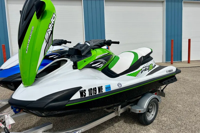 Slide: The Image of 2016 Yamaha WaveRunner FZS in green and white on a trailer, parked outdoors. - 44