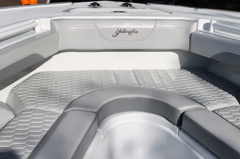 Slide: The Image of 2025 Yellowfin 36 Offshore boat interior with gray cushioned seating and hexagonal pattern flooring. - 12