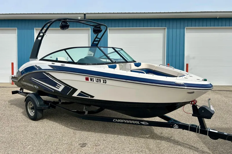 The Image of 2017 Chaparral 203 Vortex boat on trailer, parked outside blue garage. - 0