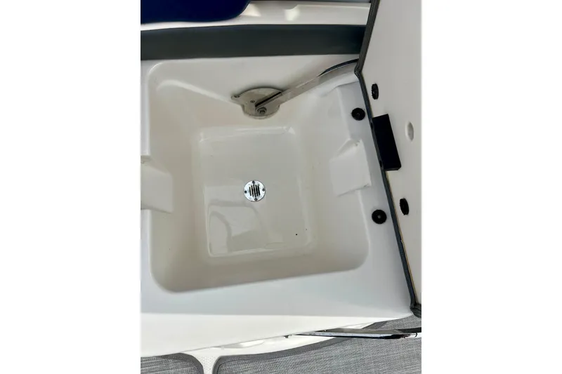 Slide: The Image of Storage compartment of 2017 Chaparral 203 Vortex boat, featuring a drain plug. - 61