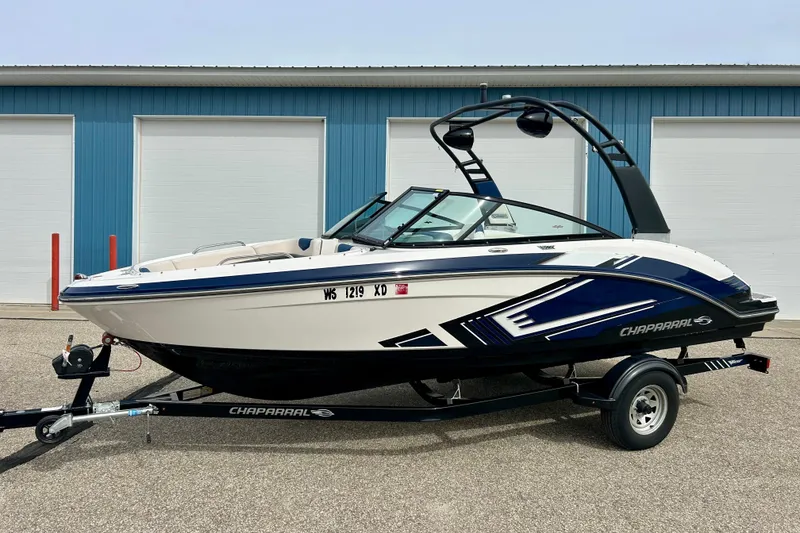 Slide: The Image of 2017 Chaparral 203 Vortex boat on trailer, parked near blue building. - 80