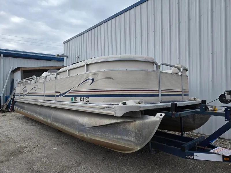Slide: The Image of 2001 Sylvan 8526 Capri pontoon boat on trailer outside warehouse. - 3