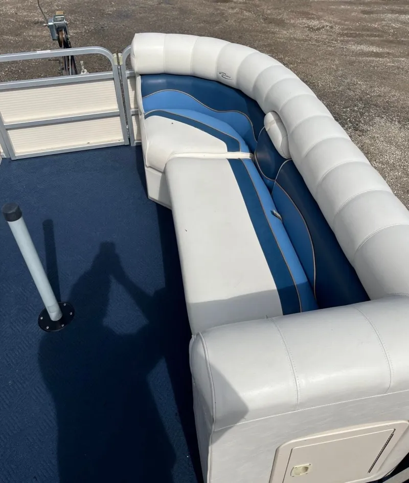 Slide: The Image of Interior of a 2001 Sylvan 8526 Capri pontoon boat with blue and white seating. - 8