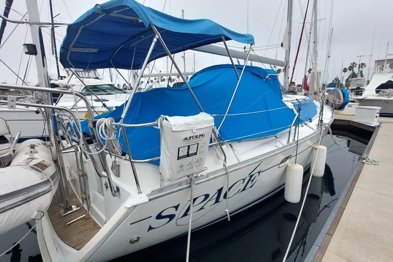 Slide: The Image of Jeanneau Sun Odyssey 43 DS sailboat, 2002 model, docked with blue canopy and lifebuoy. - 17