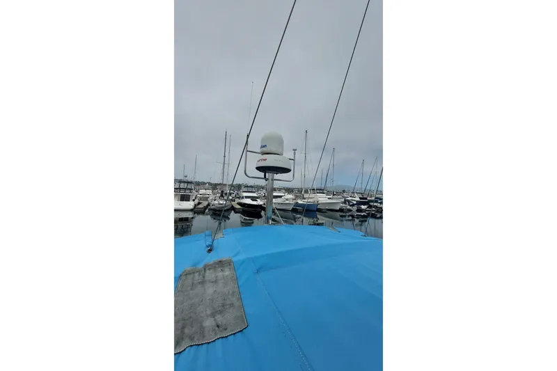 Slide: The Image of Jeanneau Sun Odyssey 43 DS sailboat, 2002 model, docked in a marina with blue cover. - 19