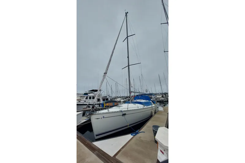 Slide: The Image of 2002 Jeanneau Sun Odyssey 43 DS sailboat docked at marina under cloudy sky. - 2