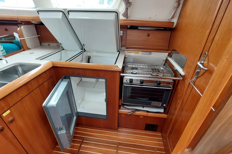 Slide: The Image of Kitchen area of 2002 Jeanneau Sun Odyssey 43 DS yacht with stove, fridge, and sink. - 50