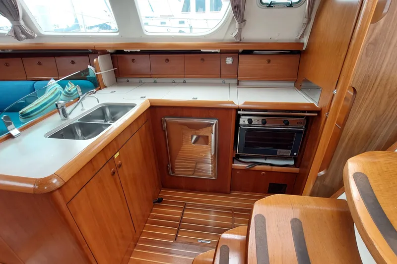 Slide: The Image of Interior of 2002 Jeanneau Sun Odyssey 43 DS yacht kitchen with wood cabinetry and appliances. - 51