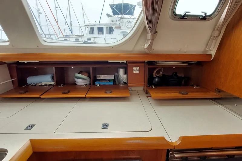 Slide: The Image of Interior of 2002 Jeanneau Sun Odyssey 43 DS yacht with open wooden cabinets. - 52