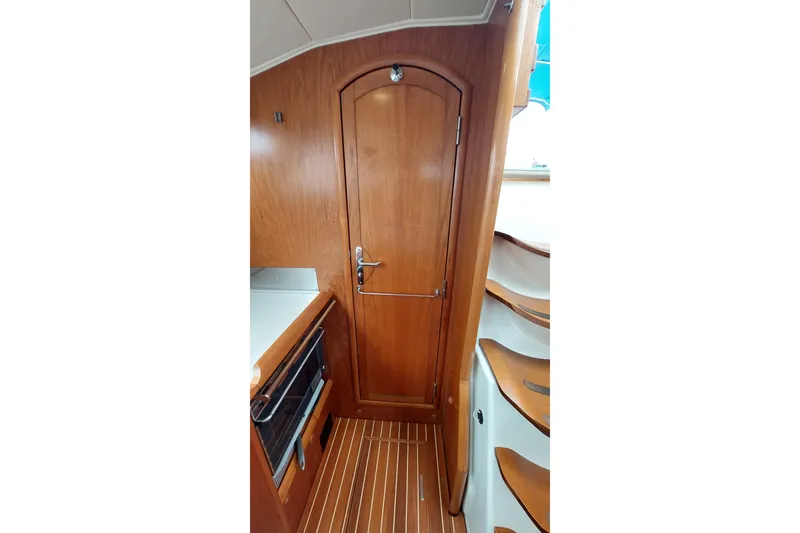 Slide: The Image of Interior of 2002 Jeanneau Sun Odyssey 43 DS, featuring wooden cabinetry and stairs. - 56