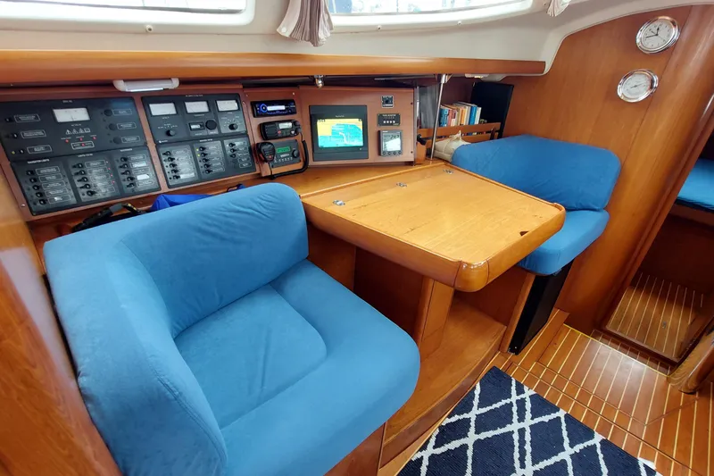 Slide: The Image of Cozy interior of 2002 Jeanneau Sun Odyssey 43 DS with navigation equipment and blue seating. - 60