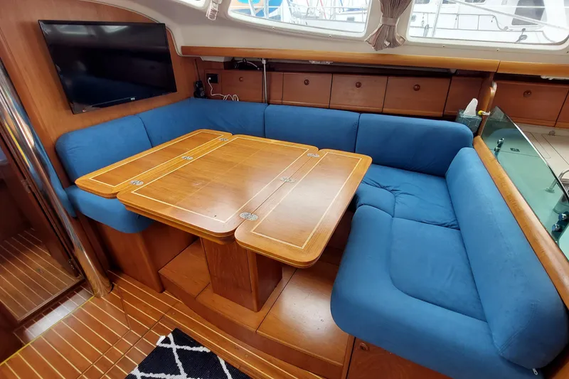 Slide: The Image of Interior of 2002 Jeanneau Sun Odyssey 43 DS with blue seating and wooden table. - 64