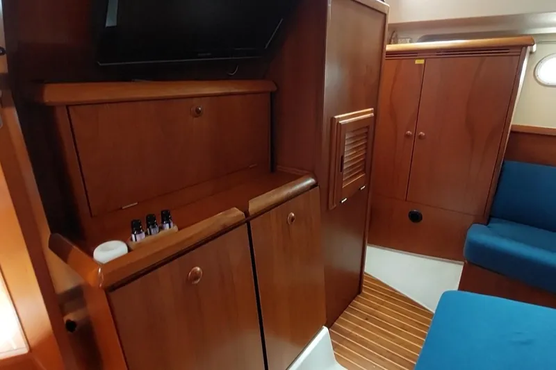 Slide: The Image of Interior of 2002 Jeanneau Sun Odyssey 43 DS with wooden cabinetry and blue seating. - 74