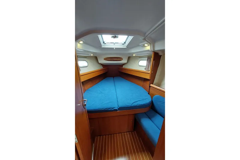 Slide: The Image of Interior cabin of 2002 Jeanneau Sun Odyssey 43 DS with blue bedding and wood finish. - 78