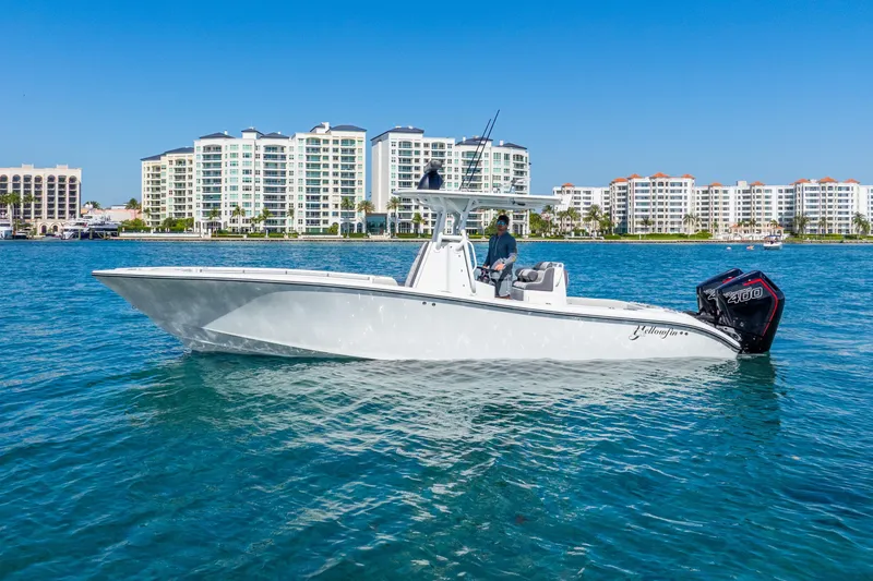 Slide: The Image of 2014 Yellowfin 29 Offshore boat on water with cityscape background. - 12