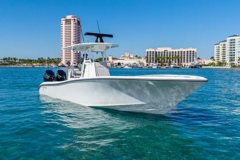 Slide: The Image of 2014 Yellowfin 29 Offshore boat on clear blue water near city skyline. - 14