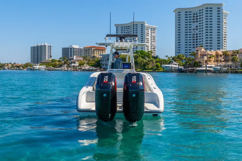 Slide: The Image of 2014 Yellowfin 29 Offshore boat with dual engines on clear blue water, cityscape background. - 16