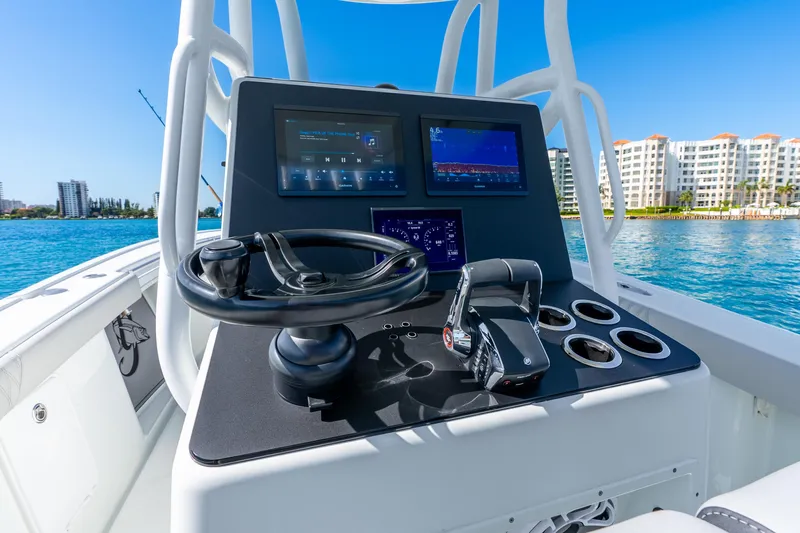 Slide: The Image of 2014 Yellowfin 29 Offshore boat dashboard with steering wheel and navigation screens. - 22