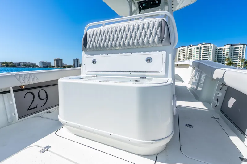 Slide: The Image of 2014 Yellowfin 29 Offshore boat interior with seating and storage, coastal skyline in background. - 28