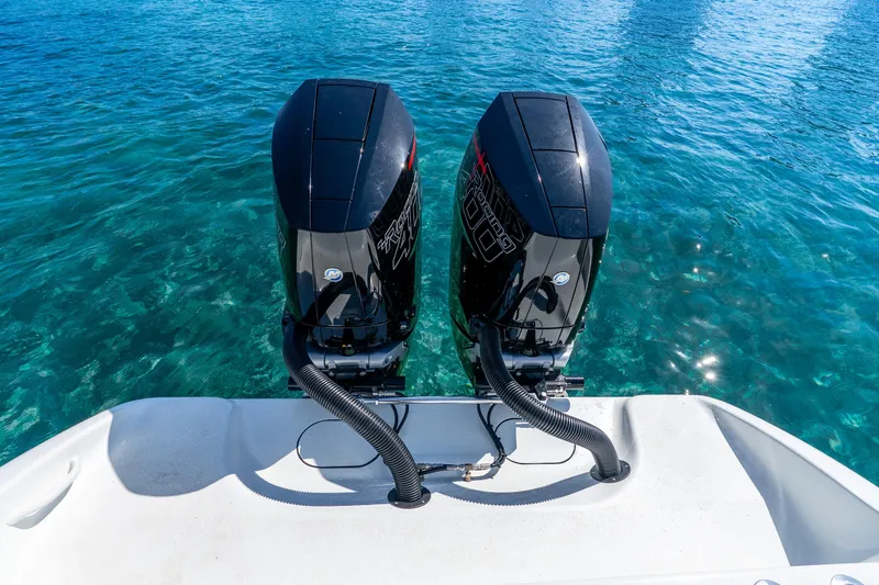 Slide: The Image of Twin outboard motors on a 2014 Yellowfin 29 Offshore boat in clear blue water. - 29