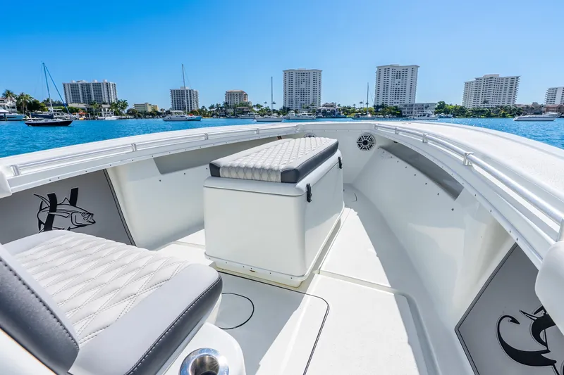 Slide: The Image of 2014 Yellowfin 29 Offshore boat interior with seating, overlooking waterfront skyline. - 31