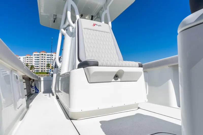 Slide: The Image of 2014 Yellowfin 29 Offshore boat interior with white seating and clear blue sky. - 34