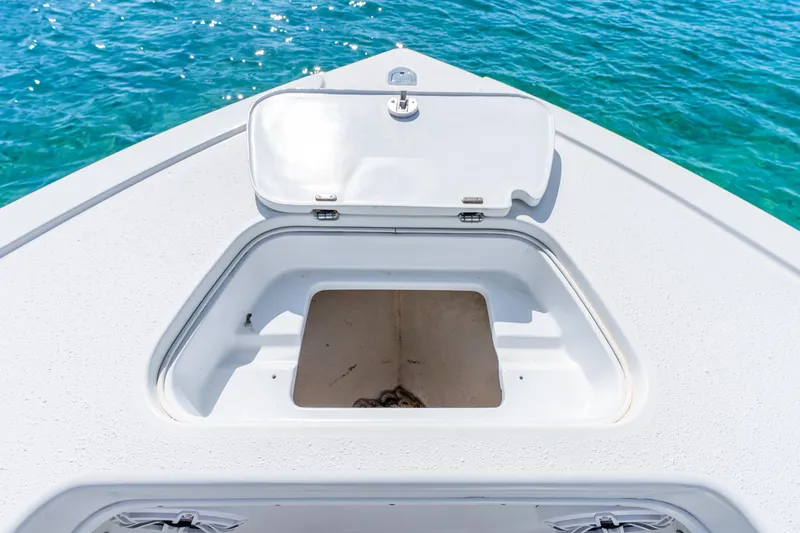 Slide: The Image of 2014 Yellowfin 29 Offshore boat with open storage compartment on deck, near clear blue water. - 35