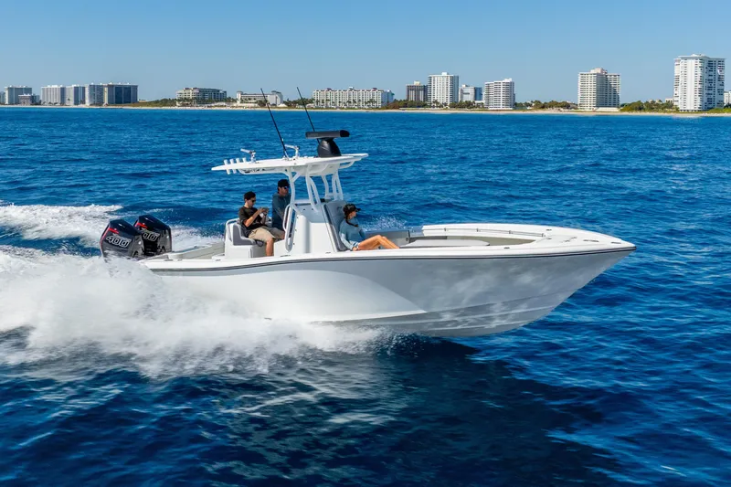 Slide: The Image of 2014 Yellowfin 29 Offshore boat cruising on blue ocean near city skyline. - 9