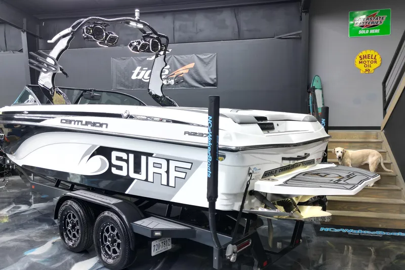 Slide: The Image of 2017 Centurion Ri237 surf boat in showroom with custom trailer and wakeboard tower. - 24