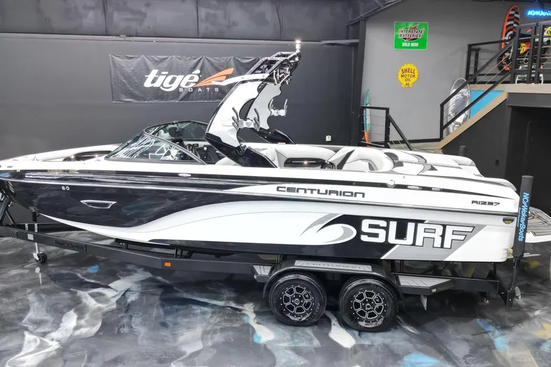 Slide: The Image of 2017 Centurion Ri237 surf boat on display in showroom with sleek design. - 27