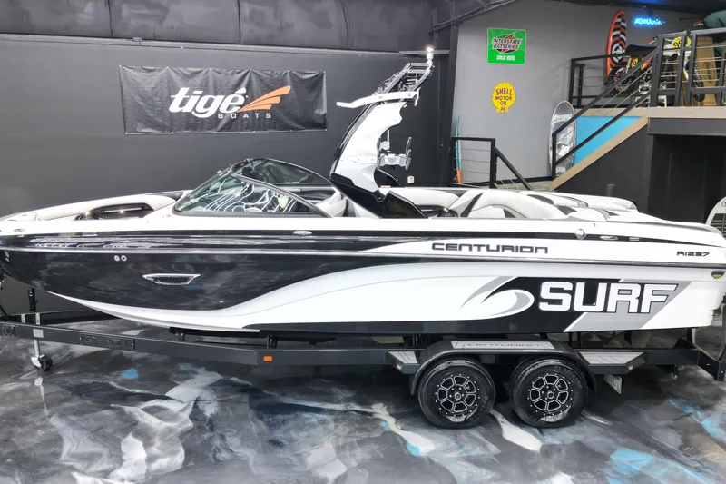 Slide: The Image of 2017 Centurion Ri237 surf boat on trailer in showroom setting. - 28
